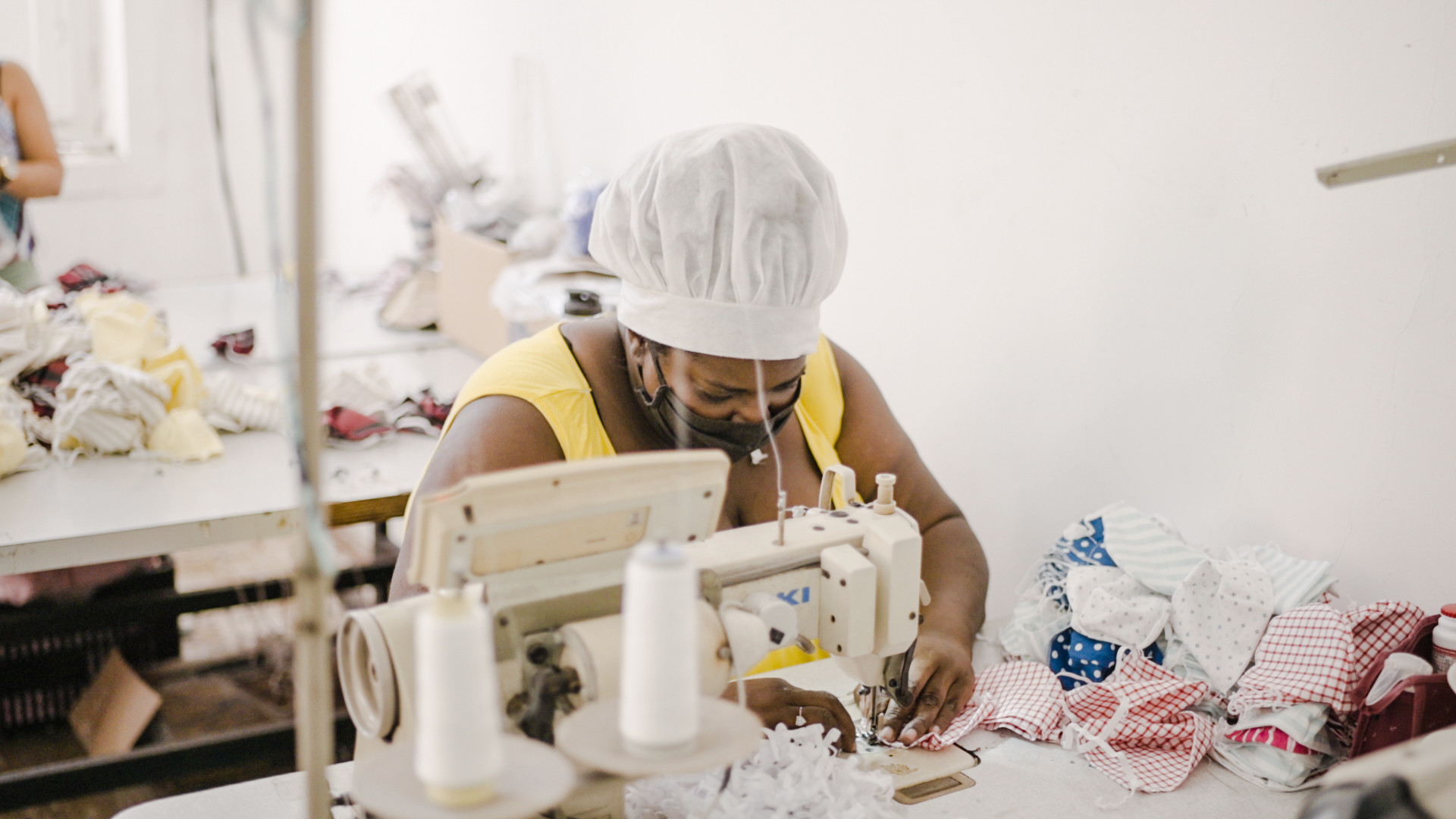 Lady participating of the Network + Income using the sewing machine.