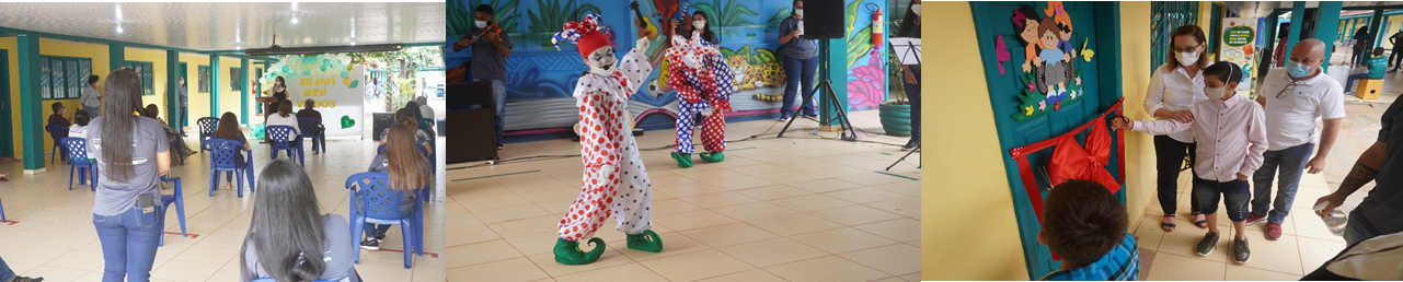 Mulheres, crianças e duas pessoas vestidas de palhaço se apresentando ao público na inauguração das salas interativas voltadas a crianças com deficiência. 